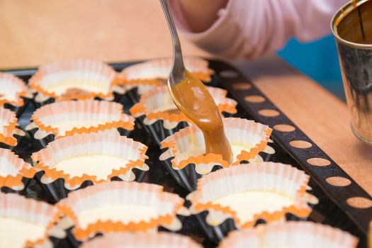 Boiled condensed milk is added as a filling into molds of muffins