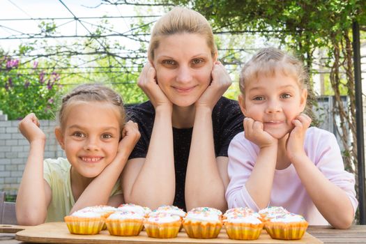 Mother and two daughters have prepared Easter cupcakes