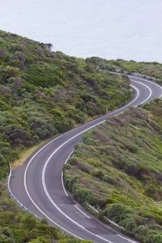 Enjoyable curves of Great Ocean Road in Victoria province of Australia.  Scenic drive along the Surf Coast with its sea views is a popular tourist attraction.  Vertical image with copy space.