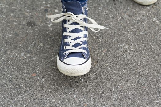 Hands girl with beautiful manicure knotted the laces on your shoelace.