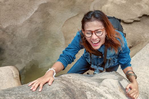 Asian woman enjoying the climbing natural stone.