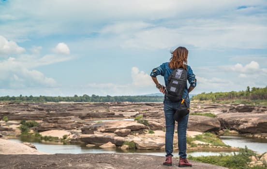  Asian woman standing outside looking at the beauty of natural stone, relaxed mood.