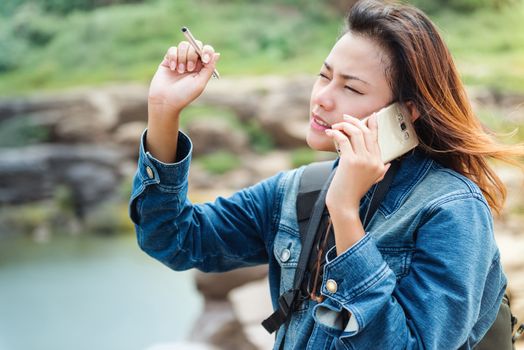 Asian women standing and talking  phone outdoor.