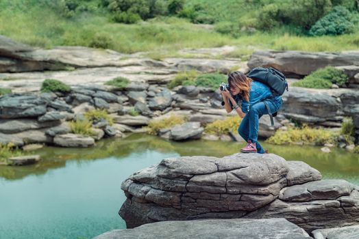  Asia woman taking a photo at Sampanbok natural stone park the grand-canyon of Ubonratchathani Thailand