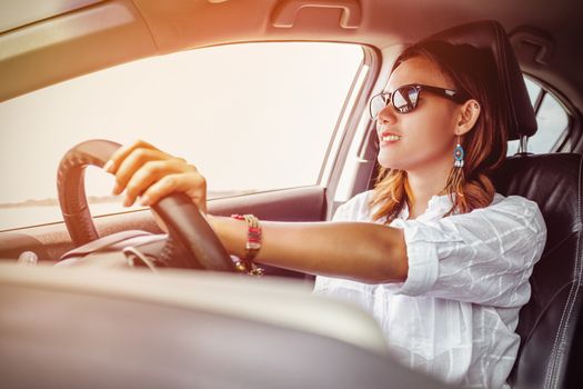 Asian woman driving a car in a happy mood.