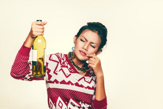 Asian woman holds up an empty bottle, mood wondering.