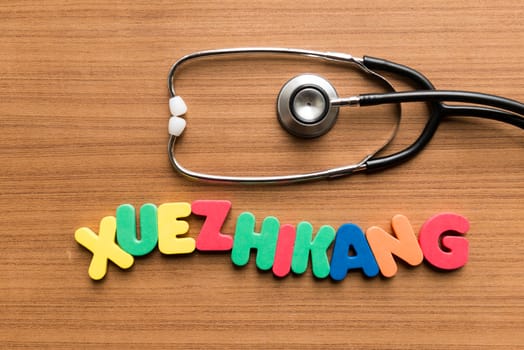 xuezhikang colorful word with stethoscope on wooden background