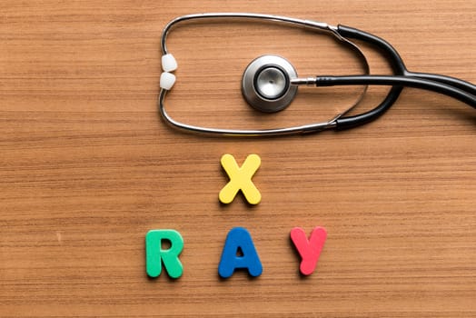 x ray colorful word with stethoscope on wooden background