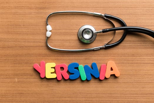 yersinia colorful word with stethoscope on wooden background