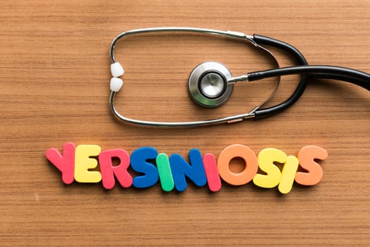 yersiniosis colorful word with stethoscope on wooden background