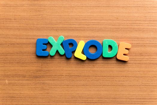 explode colorful word on the wooden background