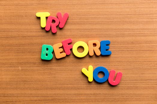 try before you colorful word on the wooden background