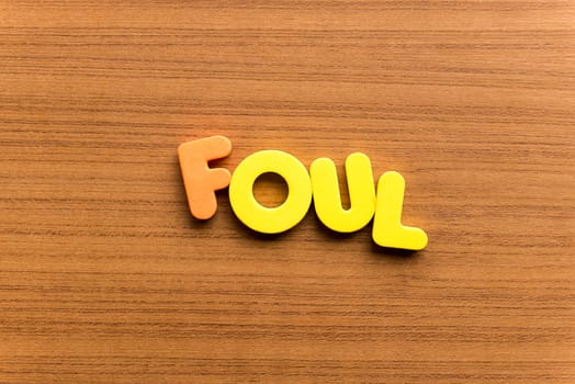 foul colorful word on the wooden background