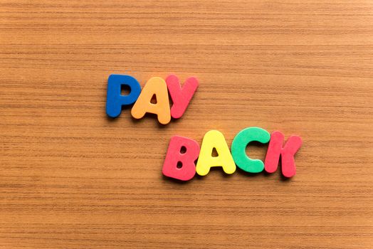 pay back colorful word on the wooden background