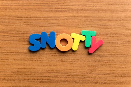 snotty colorful word on the wooden background