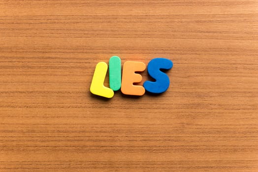 lies colorful word on the wooden background