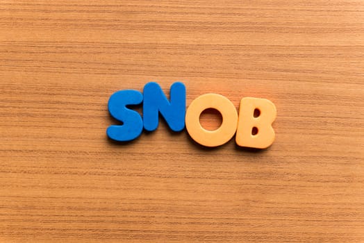 snob colorful word on the wooden background