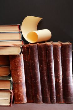 Vintage library. Old books in a row on dark background