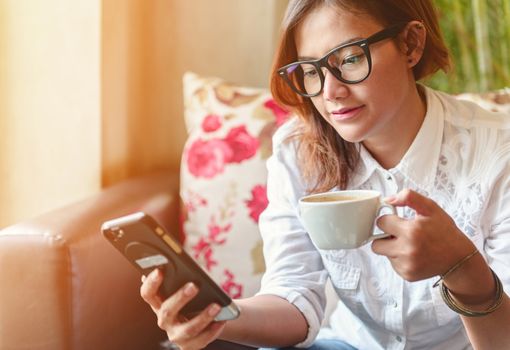 Women playing mobile phone and enjoyed drinking coffee,Focus on face