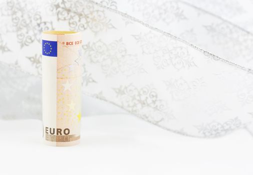 Euro currency on swirl of white snowflake ribbon background reflects shifting financial environment