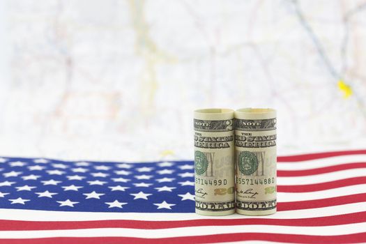 American dollars placed on USA flag with distant map as background.  Economic growth is a national issue. 