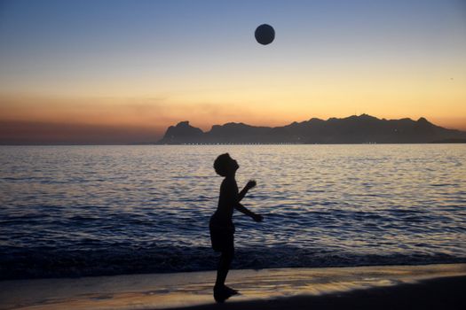 Playing soccer on the beach sunset