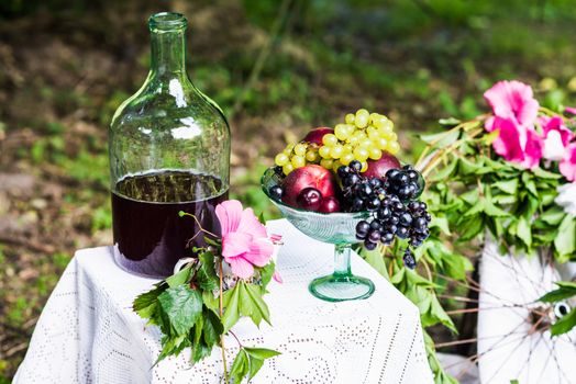 still life of fruit and red wine on a table with white tablecloth