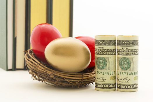 Pair of red nest eggs and two, symbolic American dollars reflect risks and dangers in business and investments.  Gold nest egg shows benefit of diversified portfolio.  