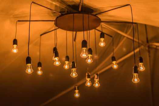 wedding decor, glowing light bulbs in an old chandelier in the tent