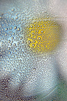 Abstract background. Drops of water on the crooked glass, shallow dof