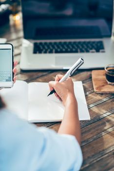 Photo Asian women are taking notes on paper, focus on Mobile