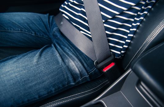 Asian woman fastening seat belt in the car,focus on jeans