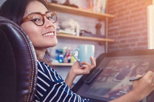 Asian woman looking down on a cup of coffee to sketch,hapy mood, focus on face