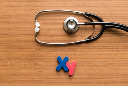 xy colorful word with stethoscope on wooden background