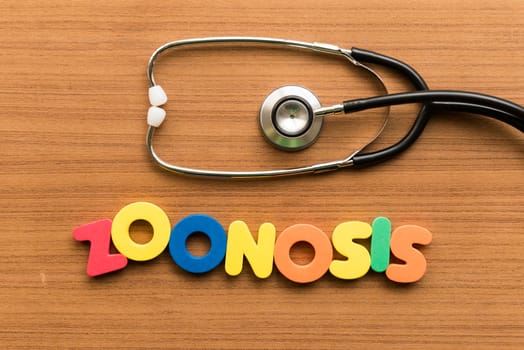 zoonosis colorful word with stethoscope on wooden background