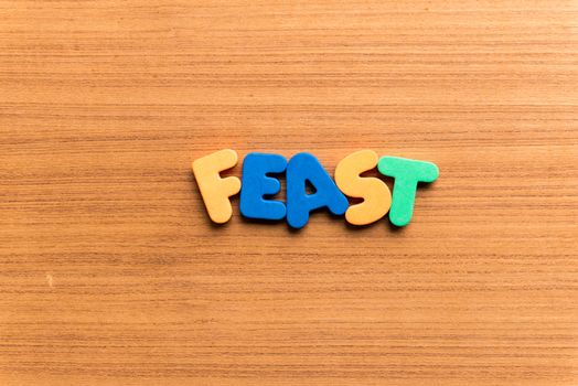feast colorful word on the wooden background