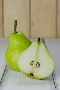 One and a half green pears over white background