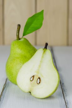 One and a half green pears over white background