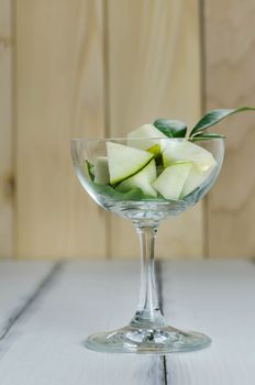 Slice of green pear in glass over white background