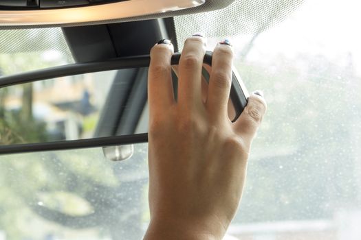 in the car the girl adjusts the rear view mirror