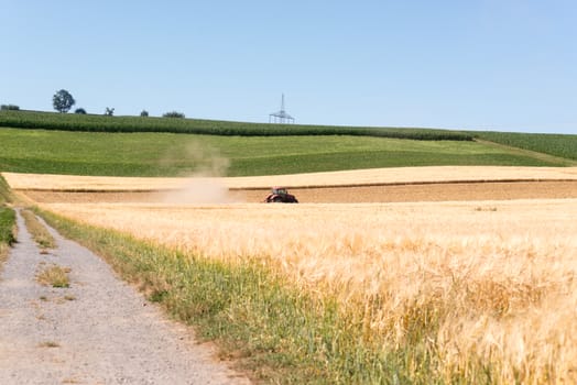 Tractor creating dust in a field