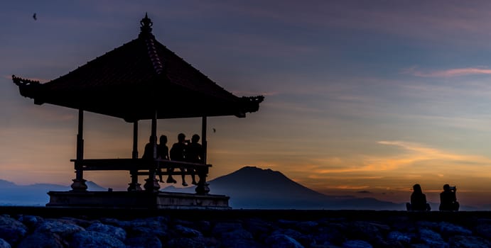 People relaxing watching a sunrise in Sanur Bali