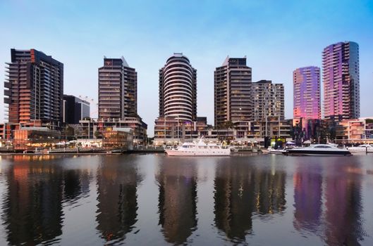 taken at the Doclands in Melbourne.  A reflection of residential towers in the water with luxuary boat in front