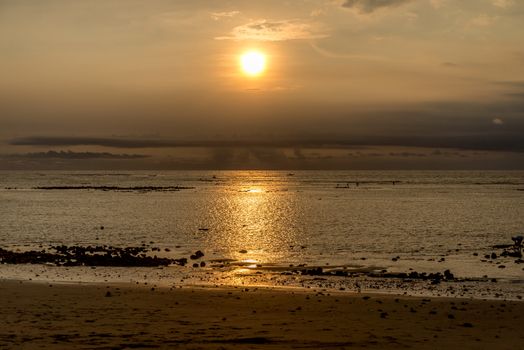 Sunset in Bali with fishermen in the distance