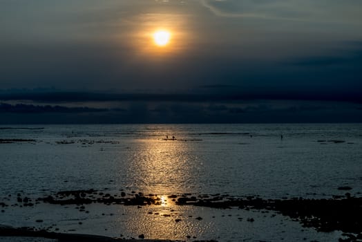 Sunset in Bali with fishermen in the distance