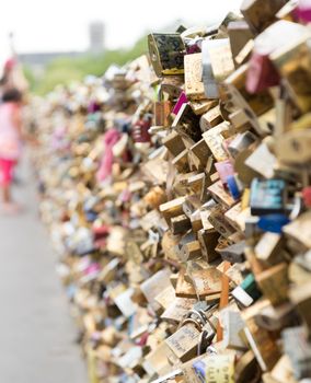 Love locks on a bridge in Paris with out of focus young girl looking at them