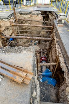 Pipe repair trench in Prague walls held up by timber bracing.