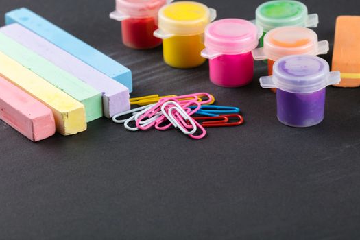 colorful crayons and gouache on a black background
