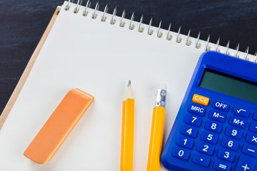 calculator and Office supplies on black background