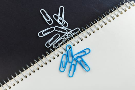 notebook and paper clips close-up on a black background